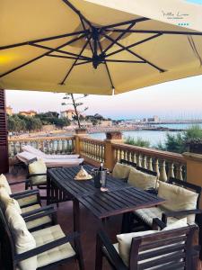 a patio with a table and chairs and an umbrella at Villa Lina in Castiglioncello