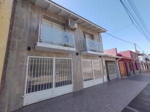 a building with gates and fences on a street at Departamento Tres Arroyos HORNERO I in Tres Arroyos
