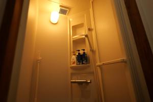a small bathroom with a door with a light on it at yol Guesthouse ヨルゲストハウス in Takeo +17 photos