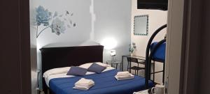a bedroom with a bed with blue sheets and pillows at B&B La Fenice in Pompei