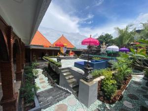 a courtyard with umbrellas in a building at Bali Chy Healing House in Dalung