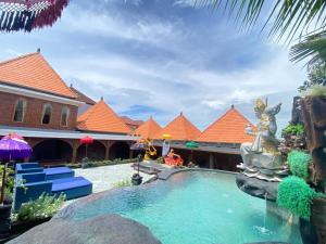 a swimming pool with a fountain in front of a building at Bali Chy Healing House in Dalung
