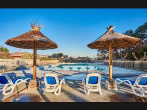 a group of chairs and umbrellas next to a pool at Luzea, Domaine Iratzia in Saint-Jean-de-Luz