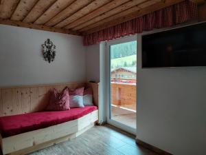 sypialnia z łóżkiem i dużym oknem w obiekcie Almstube Fritz w mieście Wald im Pinzgau
