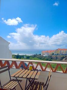 a balcony with a bench and a view of the ocean at Surf Yoga Ericeira Guest House in Ericeira