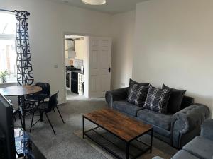a living room with a couch and a table at ResiLets - 1st Floor Plessey Road Apt in Cowpen +19 photos