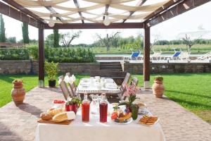 a table with food on it under a pavilion at Podere FicOlivo in Pitigliano