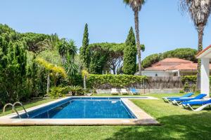 una piscina en un patio con palmeras en Villa El Cenador - Solo Familias, en Roche
