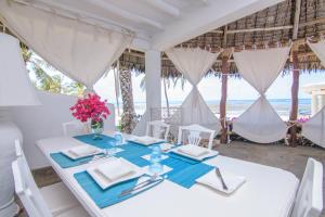 a dining room with a table with a view of the ocean at Luxury Ocean Apartment - Malindi in Malindi +16 photos