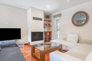 Una sala de estar con un televisor grande y un sofá. en Villa El Cenador - Solo Familias, en Roche