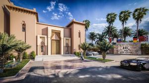 a man standing in front of a house with a car at Kenzi Azghor in Ouarzazate
