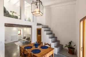 Un comedor con una mesa y una escalera. en Banyalbufar, en Banyalbufar