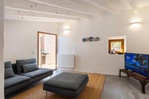 Una sala de estar con un sofá y un televisor de pantalla plana. en Banyalbufar, en Banyalbufar