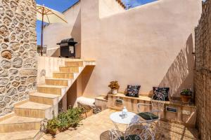Un patio con mesa y sillas y escaleras. en Banyalbufar, en Banyalbufar