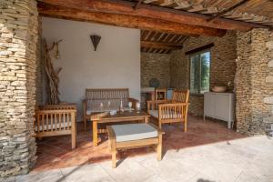 a patio with wooden chairs and a table at L'Olivette d'Uzès YourHostHelper in Uzès