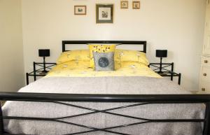 a bedroom with a bed with yellow pillows at Taigh na Laige in Flashader