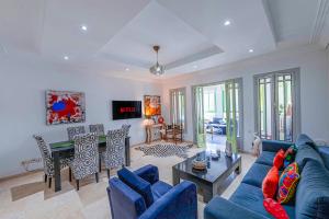 马拉喀什Luxury Apartment with Pool Large Terrace & Balconies in Hivernage Marrakech的客厅里有一张蓝色的沙发和一张桌子