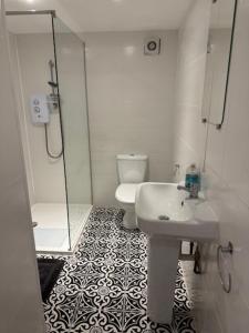 a bathroom with a toilet and a sink and a shower at Valletta House Holiday Apartments in Skegness