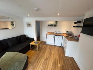a living room with a couch and a kitchen at Valletta House Holiday Apartments in Skegness