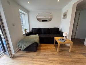 a living room with a black couch and a table at Valletta House Holiday Apartments in Skegness