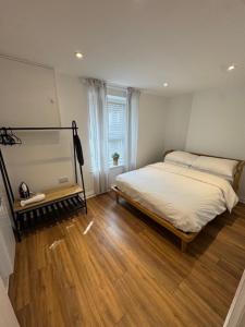 a bedroom with a bed and a wooden floor at Valletta House Holiday Apartments in Skegness
