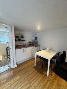 a living room with a table and a kitchen at Valletta House Holiday Apartments in Skegness