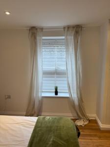 a bedroom with a bed and a window at Valletta House Holiday Apartments in Skegness