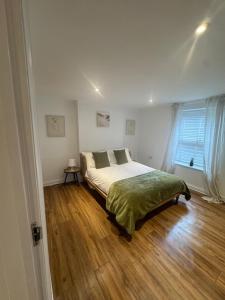 a bedroom with a bed and a wooden floor at Valletta House Holiday Apartments in Skegness