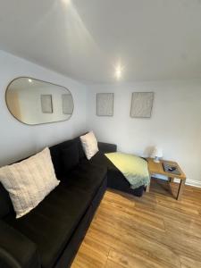a living room with a black couch and a table at Valletta House Holiday Apartments in Skegness