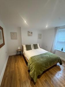 a bed in a room with a wooden floor at Valletta House Holiday Apartments in Skegness