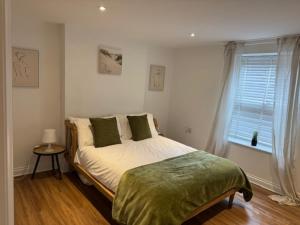a bedroom with a large bed with a window at Valletta House Holiday Apartments in Skegness