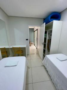 a bedroom with two beds and a table and chairs at FLAT's TAVARES 102 in Garanhuns +12 photos