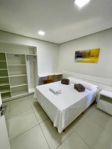 a bedroom with a white bed in a room at FLAT's TAVARES 102 in Garanhuns