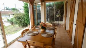 a dining room with a table and chairs and a window at L'Evasion, maison spacieuse, véranda, parking in Saint-André-de-Cubzac
