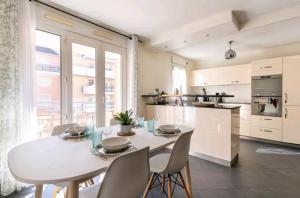a kitchen and dining room with a white table and chairs at L'Atrium Hyper centre pour rejoindre Genève in Saint-Julien-en-Genevois