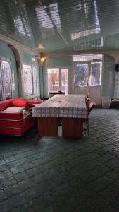a room with a bed and a couch and windows at Загородный дом Акжар in Aktobe