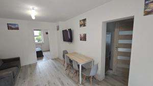 a living room with a table and a tv on a wall at Apartament przy Sosnowej in Lublin