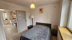 a bedroom with a bed and a door to a kitchen at Apartament przy Sosnowej in Lublin