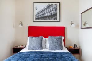 a bedroom with a bed with a red headboard at The Clifton Hotel Bristol in Bristol