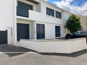 a white house with a car parked in front of it at Le Petit Fabre in La Roche-sur-Yon