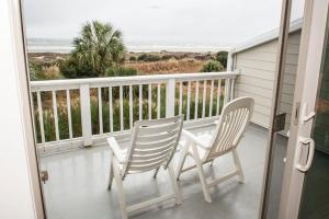 two chairs and a table on a balcony at Beach Club Villa 39 by Wild Dunes, Oceanfront in Isle of Palms