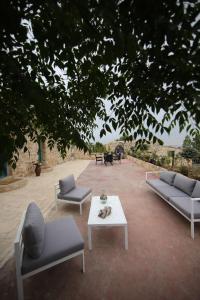 a patio with three couches and a coffee table at The Inn in Jbeil