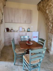 a dining room with a table and chairs and a kitchen at The Inn in Jbeil