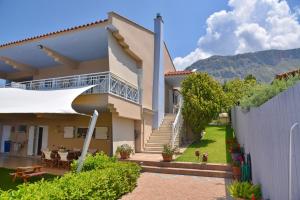 a house with a patio and a fence at VillaSunset in Paleros