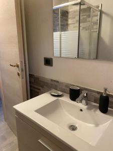 a bathroom with a white sink and a mirror at Appartamento I 2 archi in Cremona +10 photos