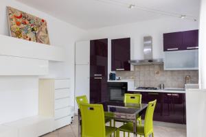 a kitchen with a dining table and yellow chairs at Andrea's Dépendance in Letojanni
