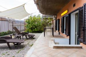a patio with chairs and a table and an umbrella at Andrea's Dépendance in Letojanni