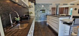 una cucina con un lavello e un piano di lavoro di VILLA LA MAZAL, Bord de Mer, Piscine, Double Baignoire Balneo, Climatisation a Sète