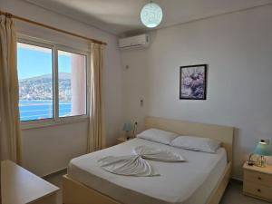 a bedroom with a bed with a large window at Olsen Bellavista Apartments in Sarandë