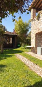 una casa de piedra con un banco en el patio en Holiday House Sant'Annunziata, en Monte Rubiaglio